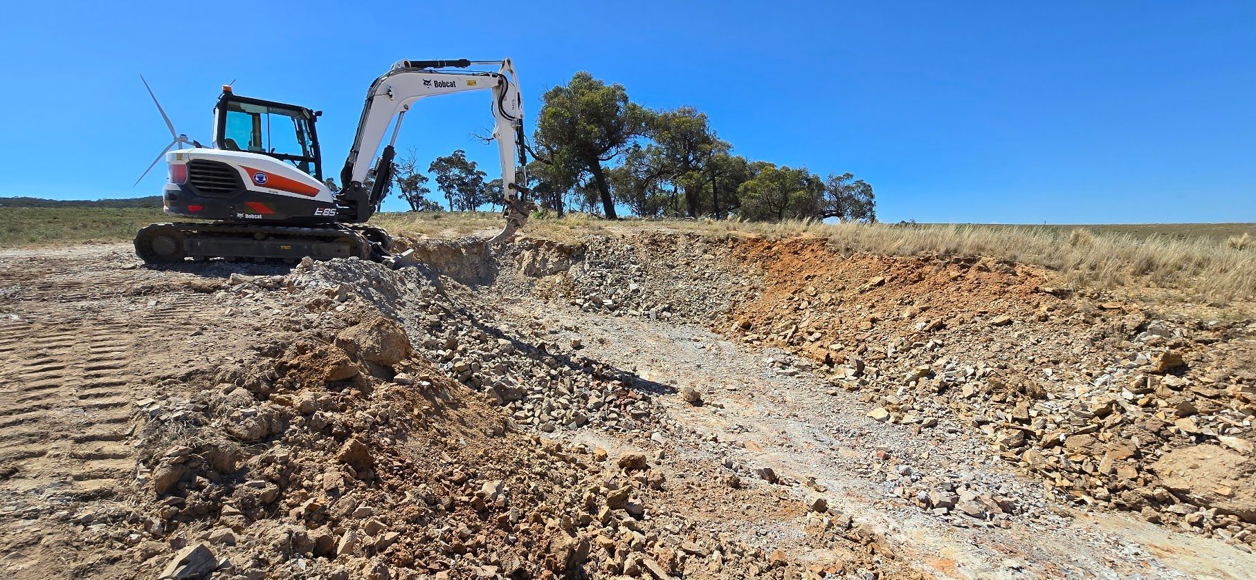 An excavator is digging a hole in the middle of a lake