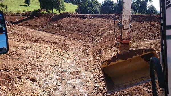 A bulldozer is moving dirt on a dirt road.