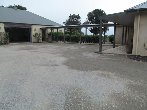 A driveway leading to a house with a carport