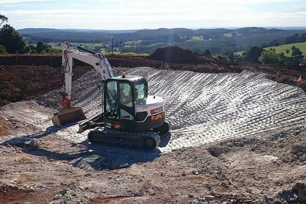 A bulldozer is sitting in the middle of a dirt field.