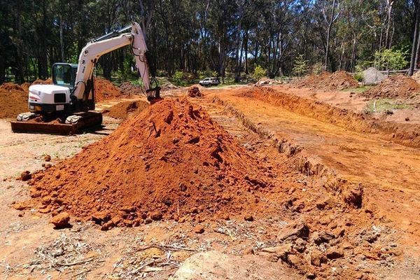 A large pile of dirt is being moved by an excavator