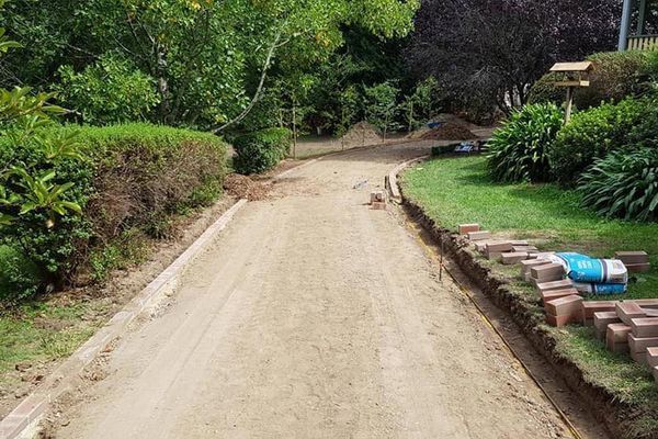 A dirt road going through a lush green park.