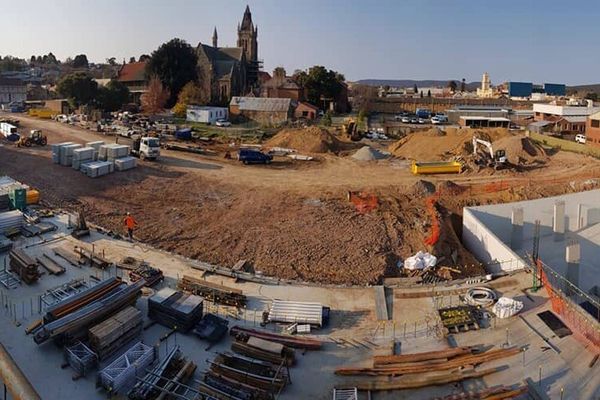 An aerial view of a construction site with a church in the background