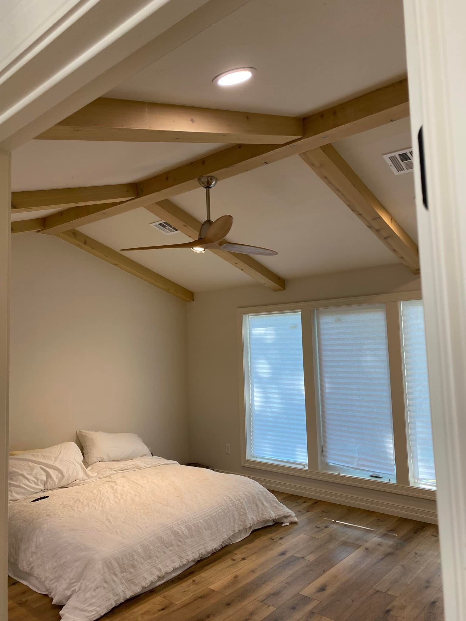 A bedroom with a bed and a ceiling fan.