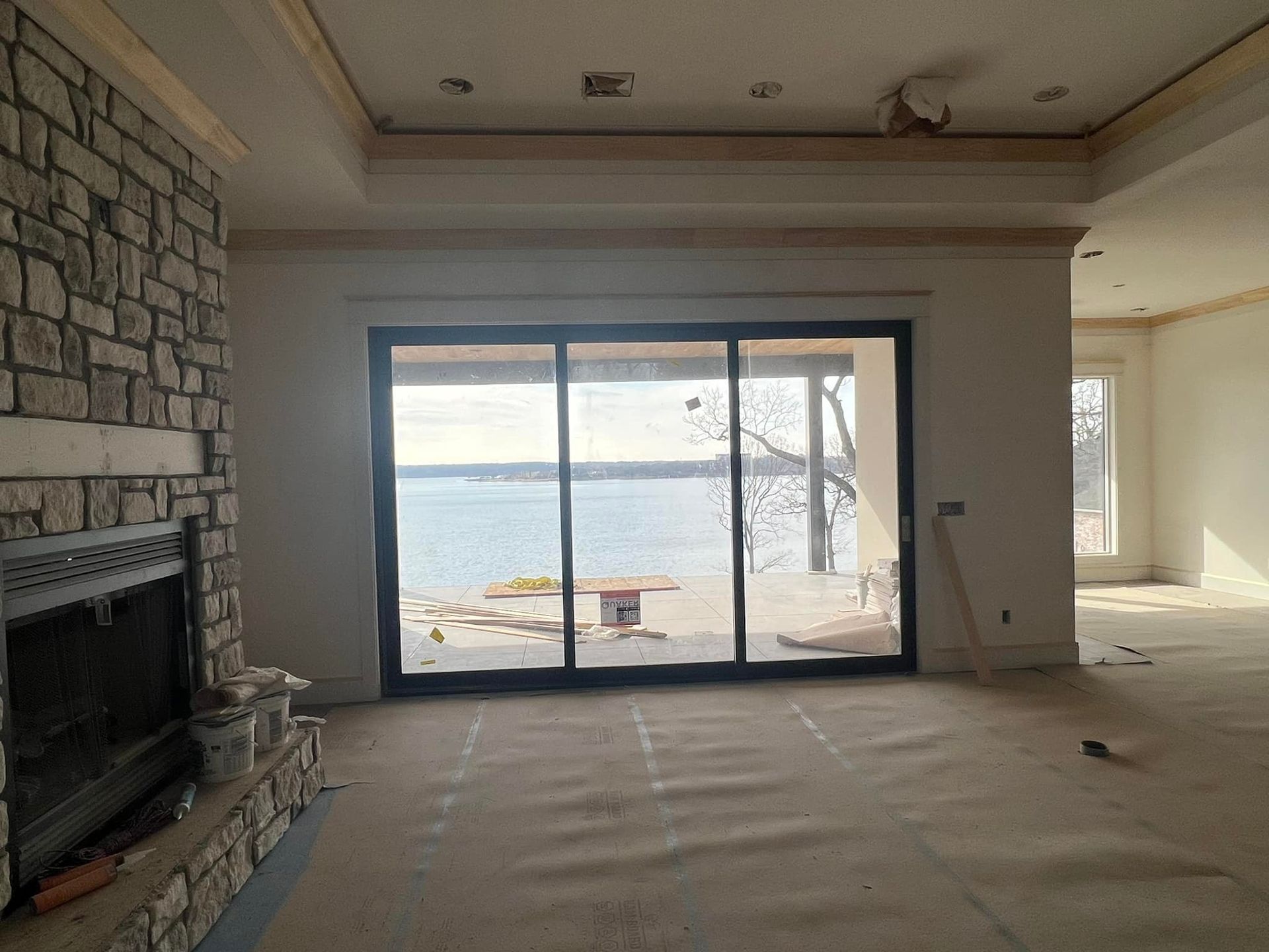 An empty living room with a fireplace and sliding glass doors