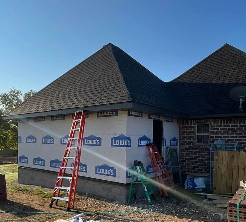 A ladder is sitting in front of a house that is being remodeled