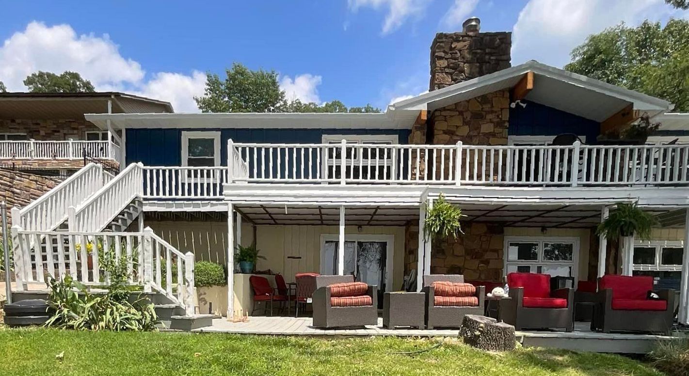 A large house with a lot of furniture on the porch.