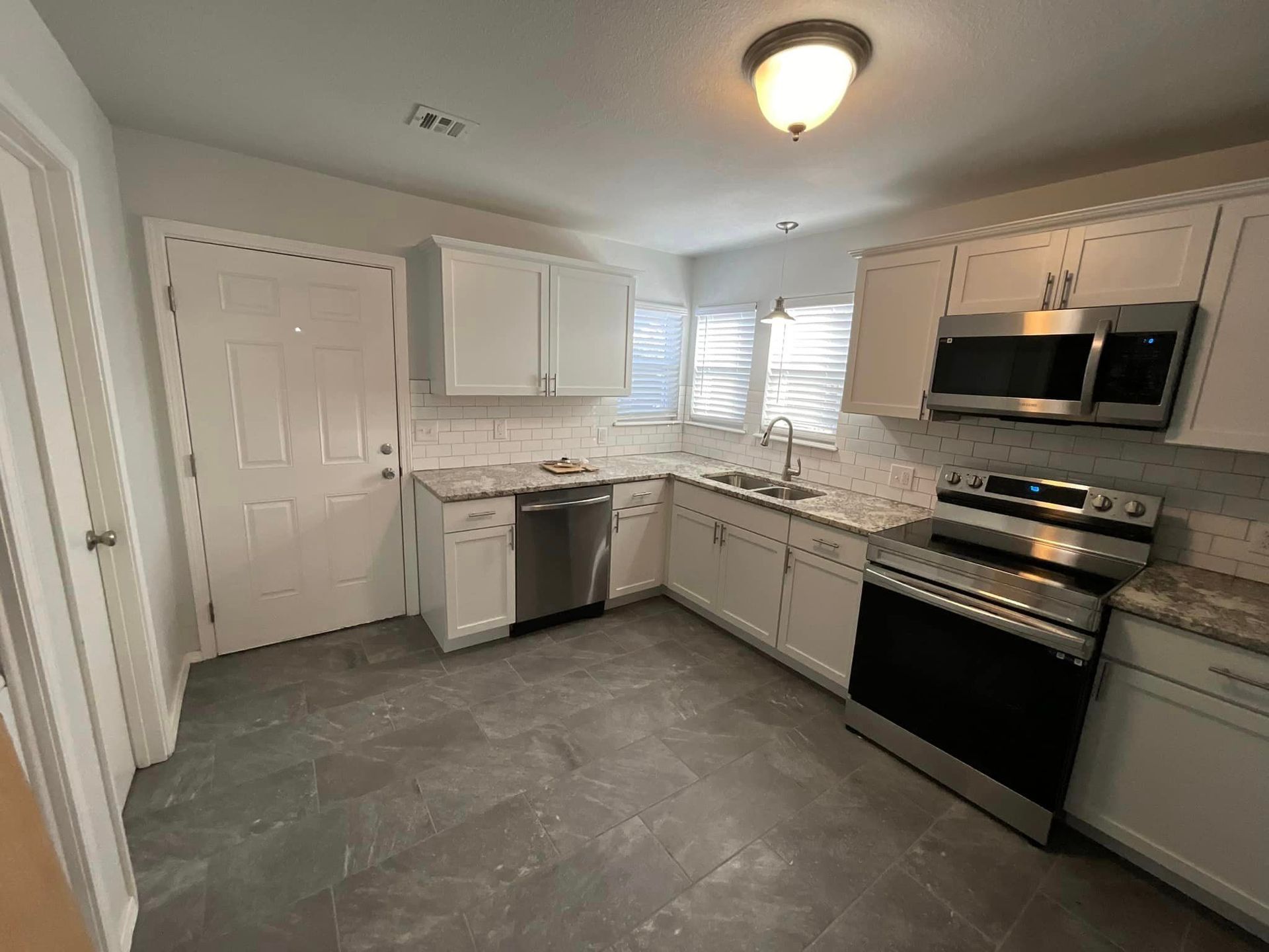A kitchen with white cabinets and stainless steel appliances.