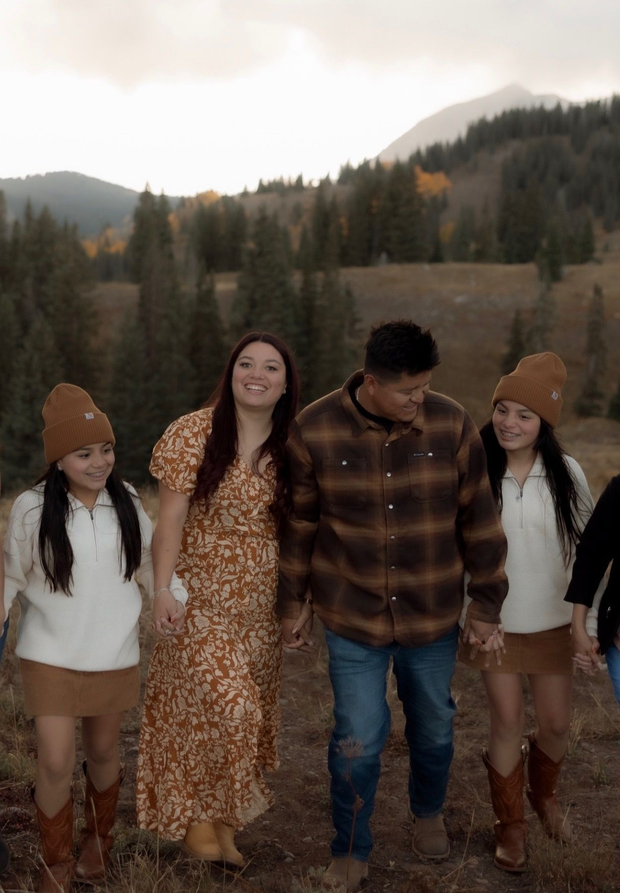 Yellow-gloved hand wiping a blue cloth on a white surface.