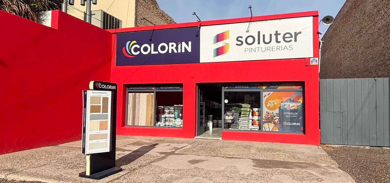 Una tienda de pintura roja Colorin Soluter con exposición de muestras en el exterior.