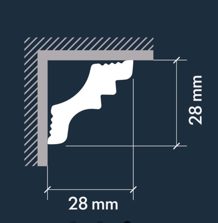 Moldura de corona blanca a lo largo de la parte superior de una pared y esquina del techo de color gris.