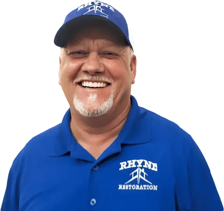 Man smiling, wearing blue cap and polo shirt with 