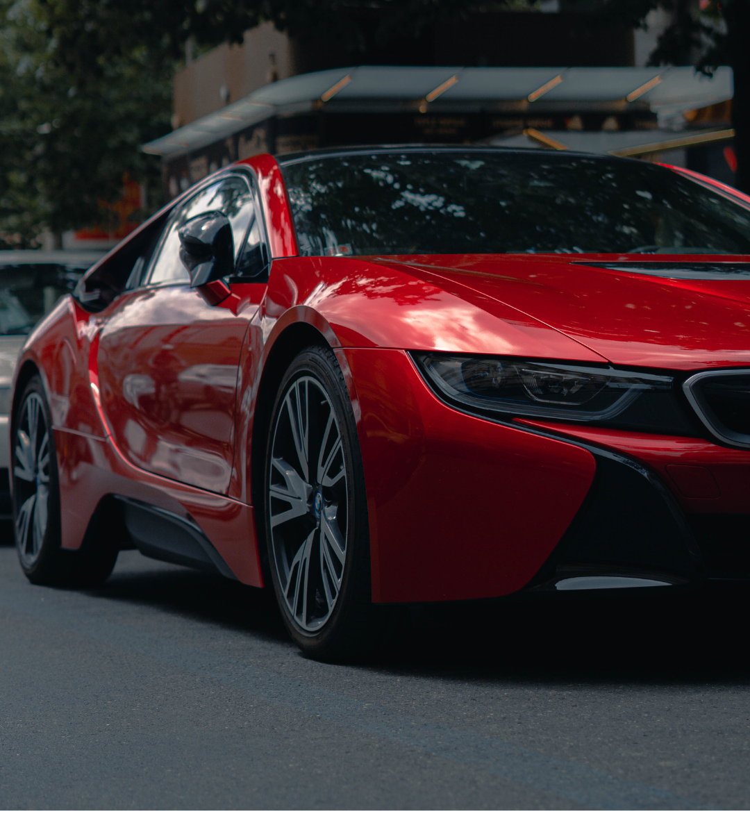 A red sports car is parked on the side of the road