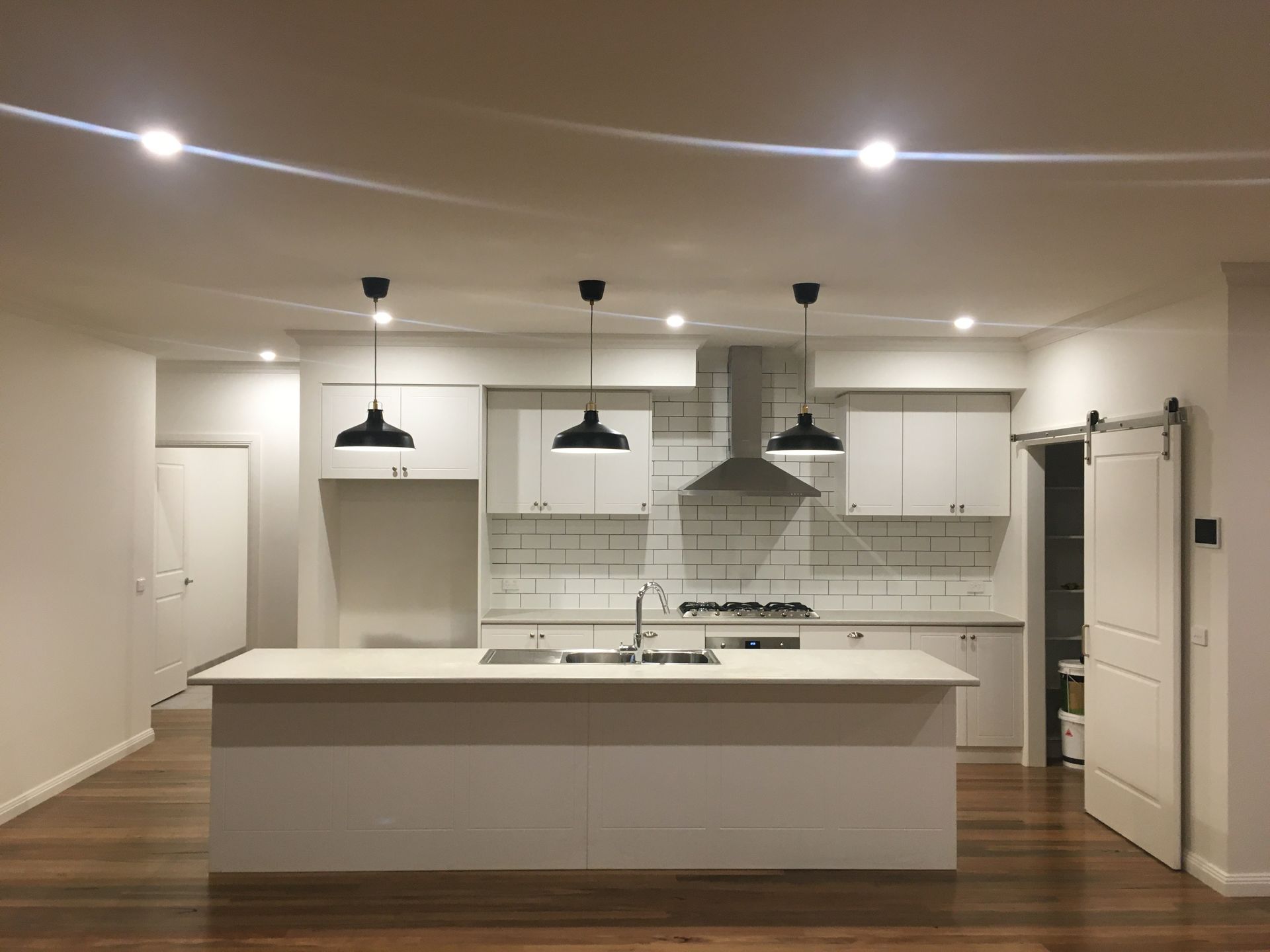 A kitchen with white cabinets and a large island.