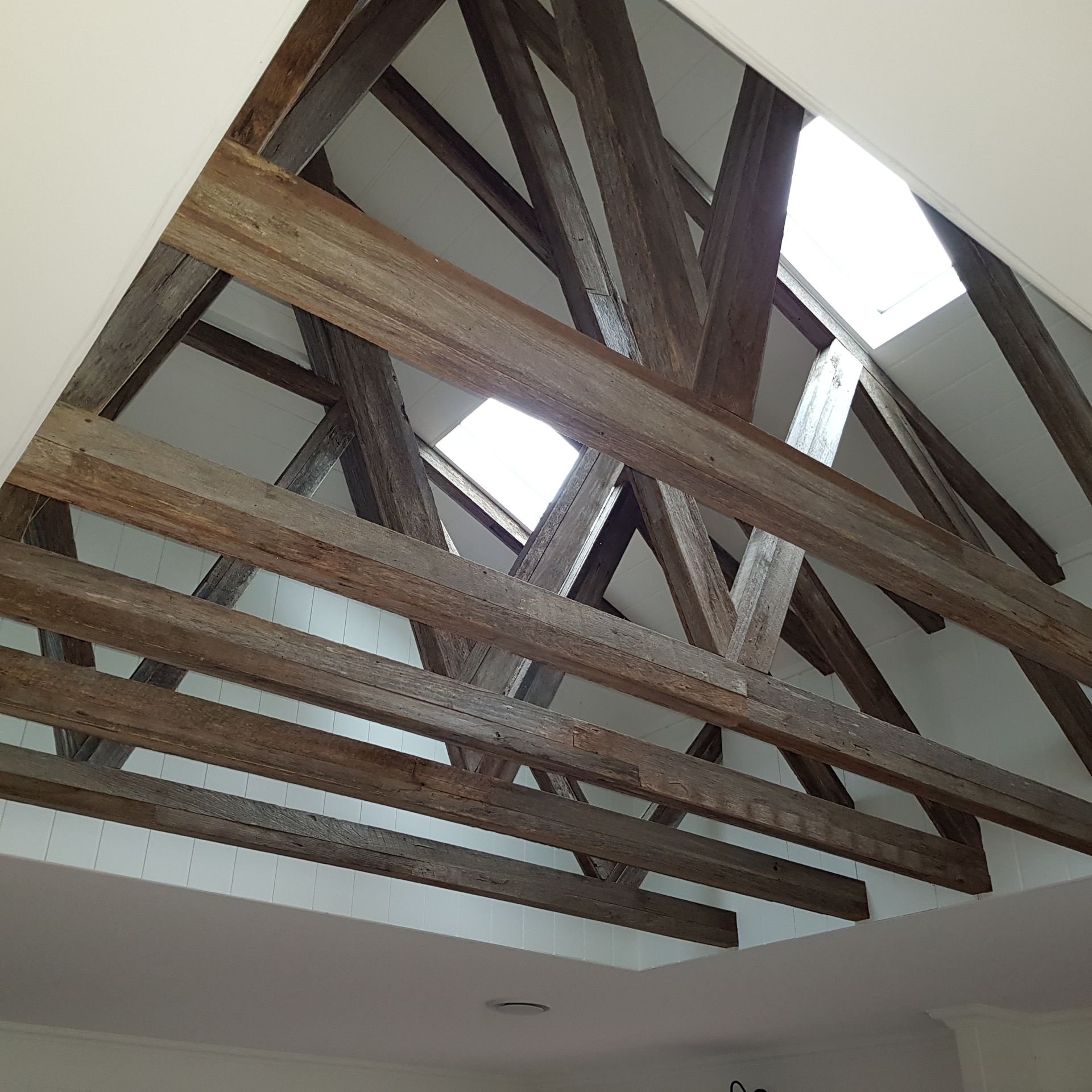 Looking up at the ceiling of a building with wooden beams