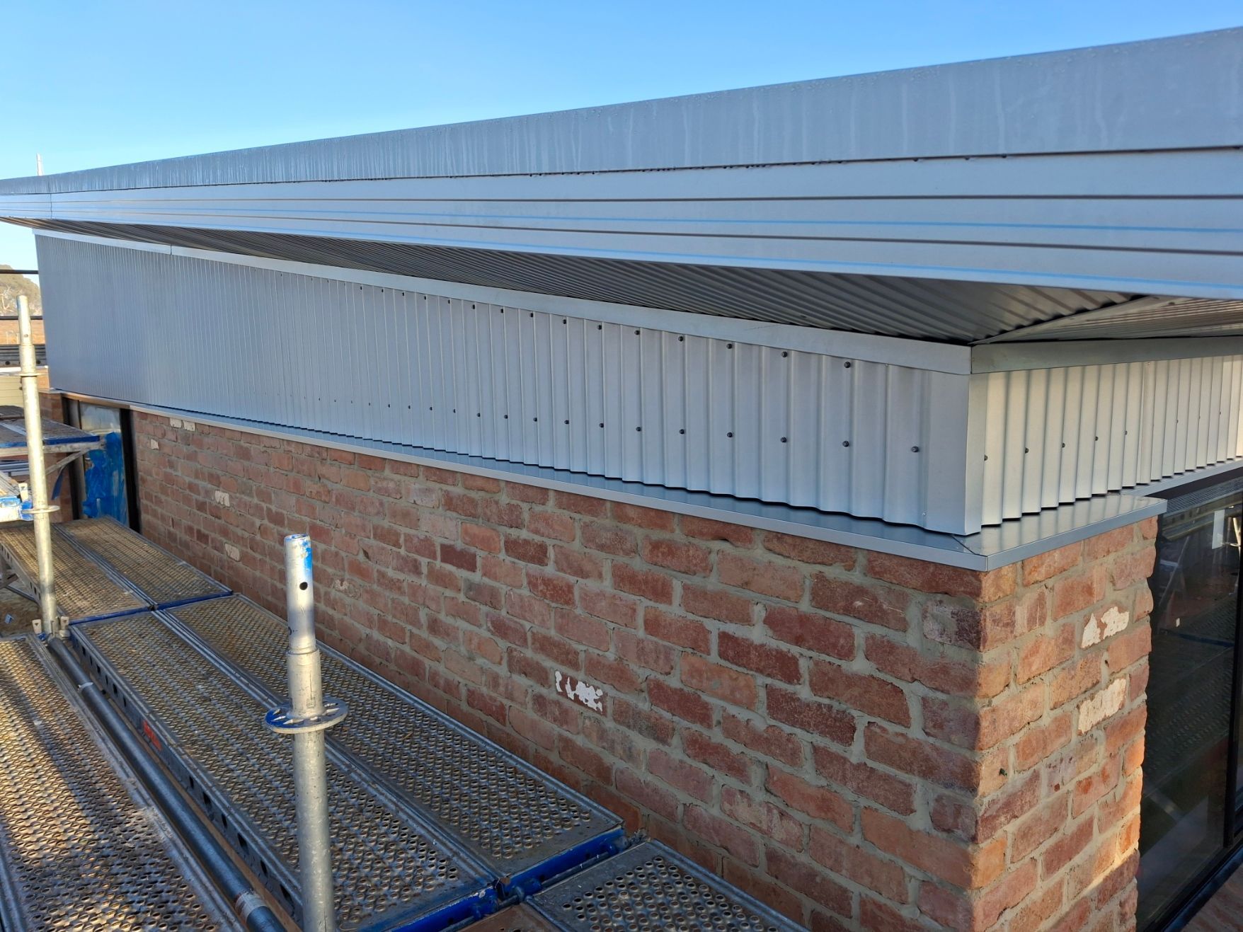 A brick building with a white roof is being built.