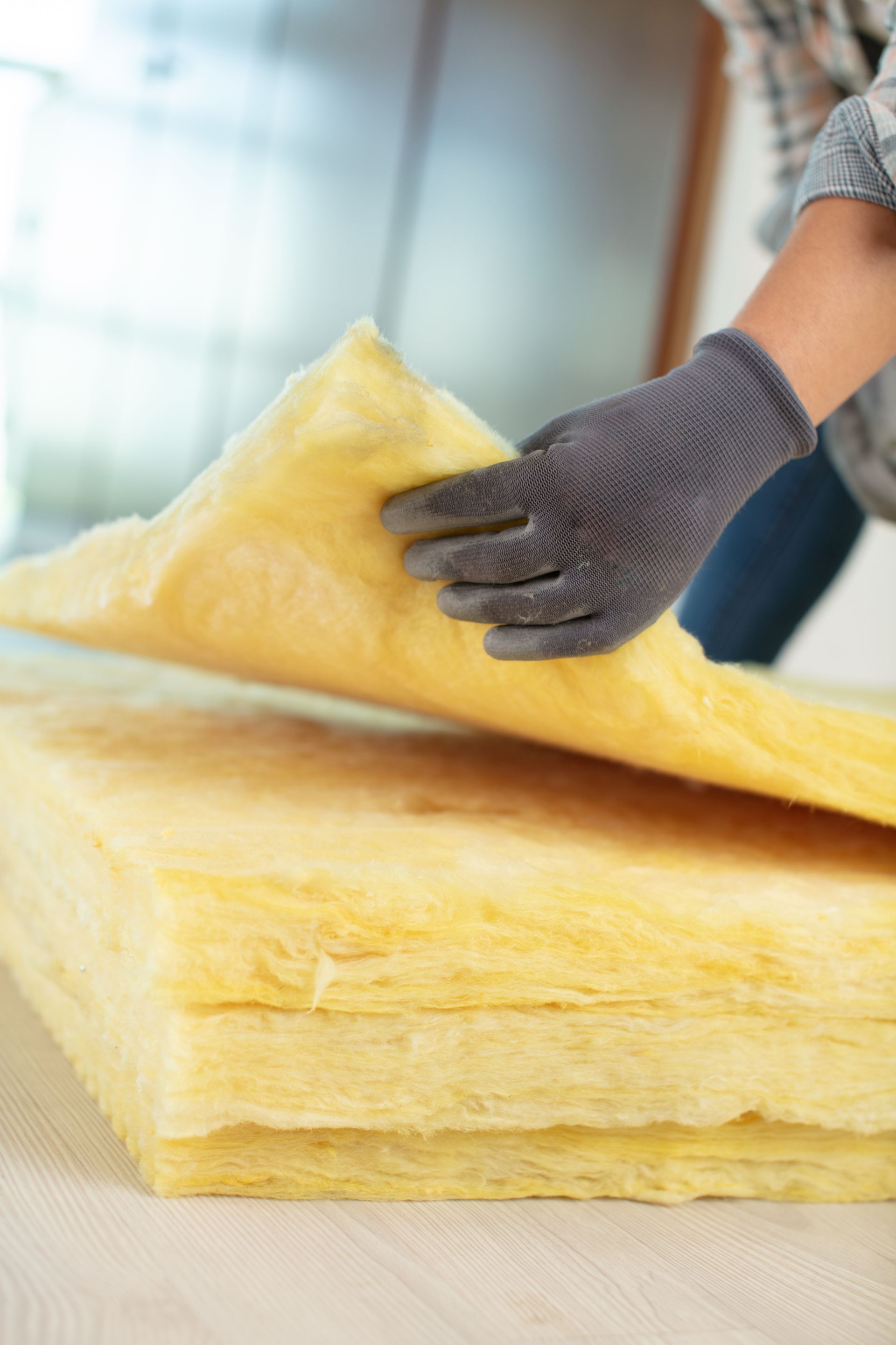 Una persona che indossa i guanti tiene in mano un pezzo di materiale isolante.