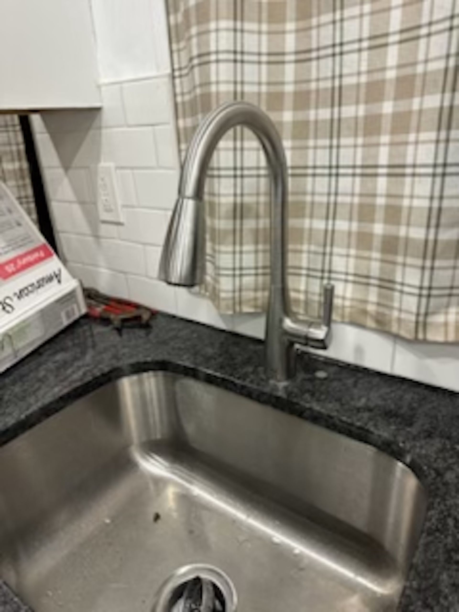 A stainless steel sink with a faucet in a kitchen.
