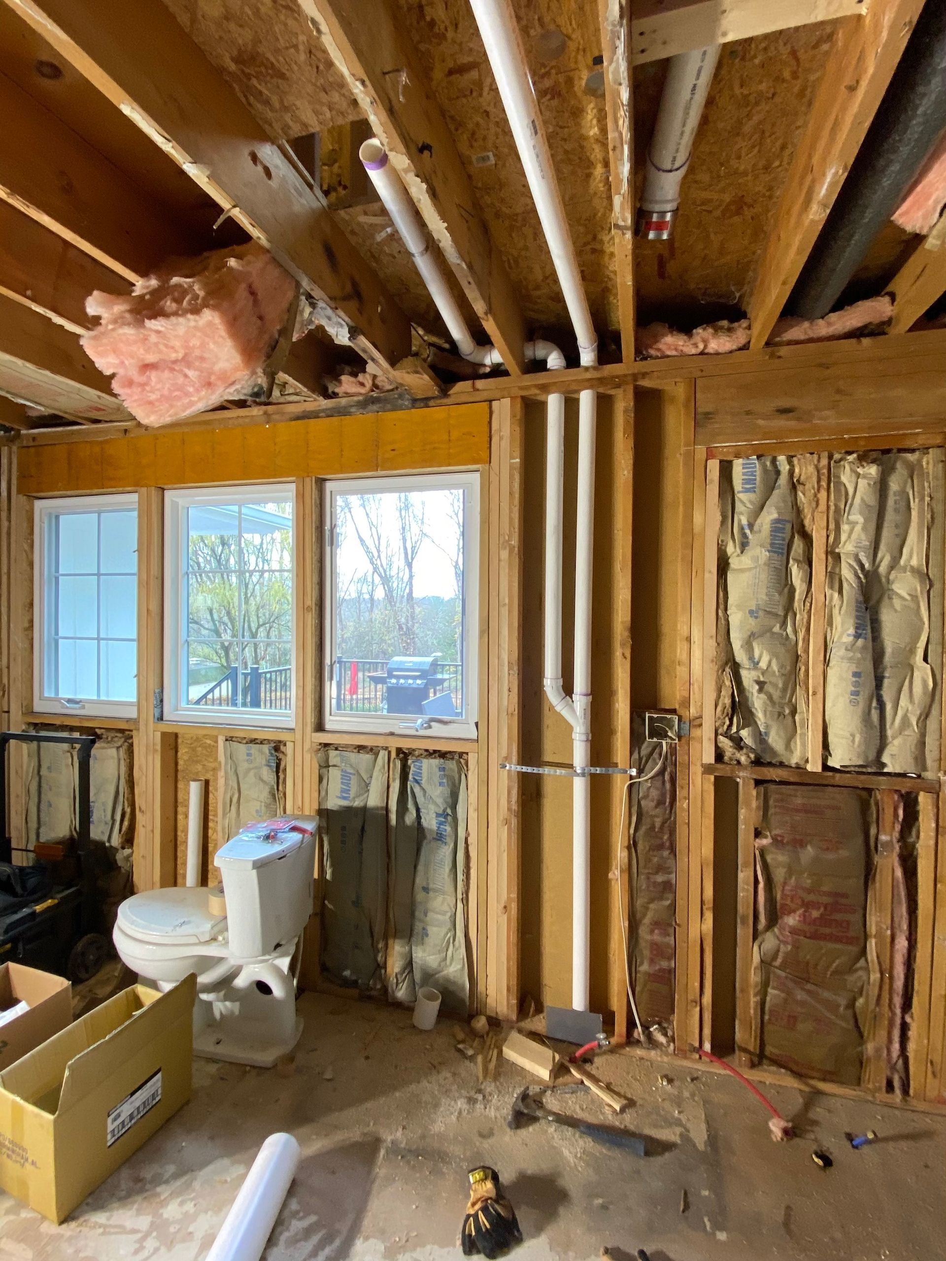 A bathroom under construction with a toilet and a box on the floor.