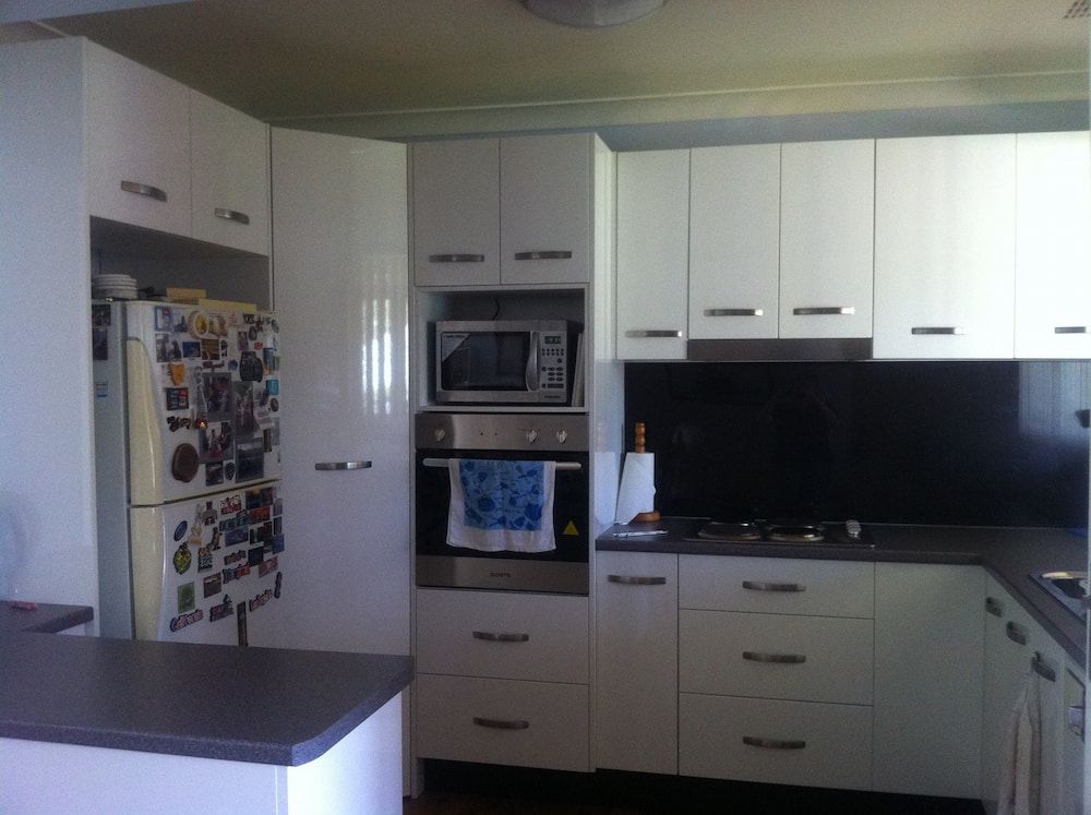 A Kitchen With White Cabinets And Stainless Steel Appliances — Standfast Cabinets In Tuggerah, NSW