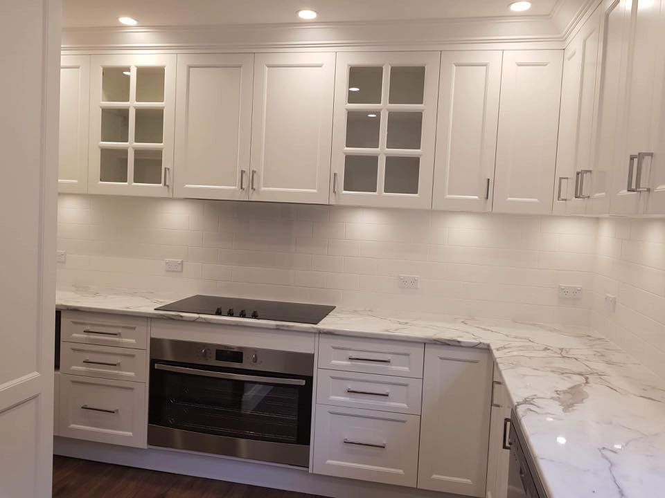 A Kitchen With White Cabinets, Stainless Steel Appliances, And Marble Counter Tops — Standfast Cabinets In Tuggerah, NSW