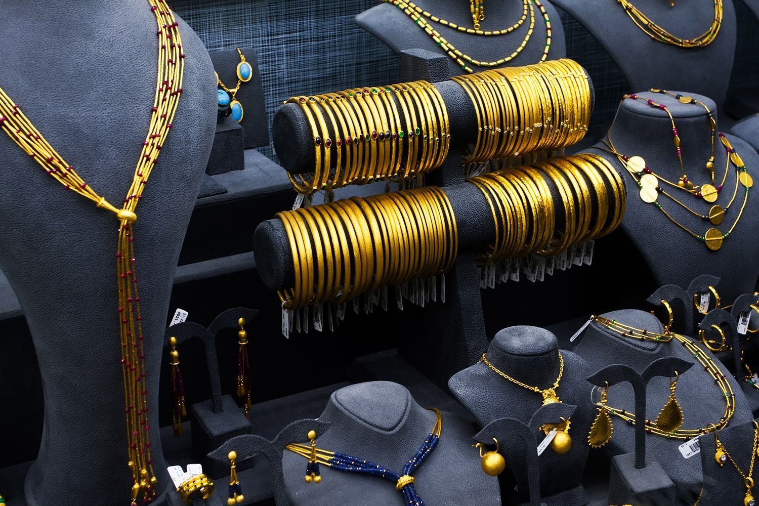 Gold jewelry display on black velvet busts and stands. Bangles, necklaces, earrings. Gold jewelry display on black velvet busts and stands. Bangles, necklaces, earrings.