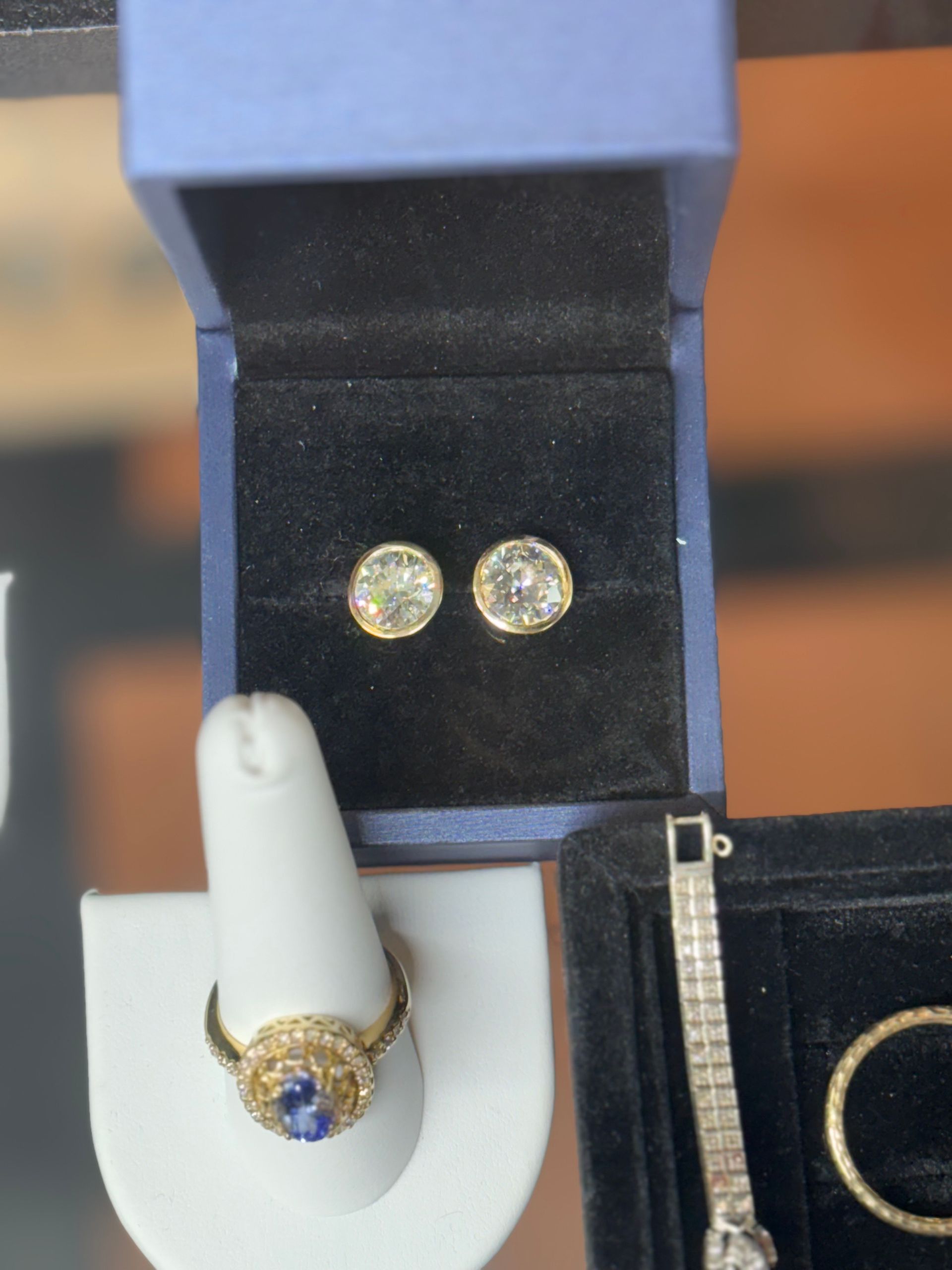 Gold jewelry displayed on beige stands in a store.