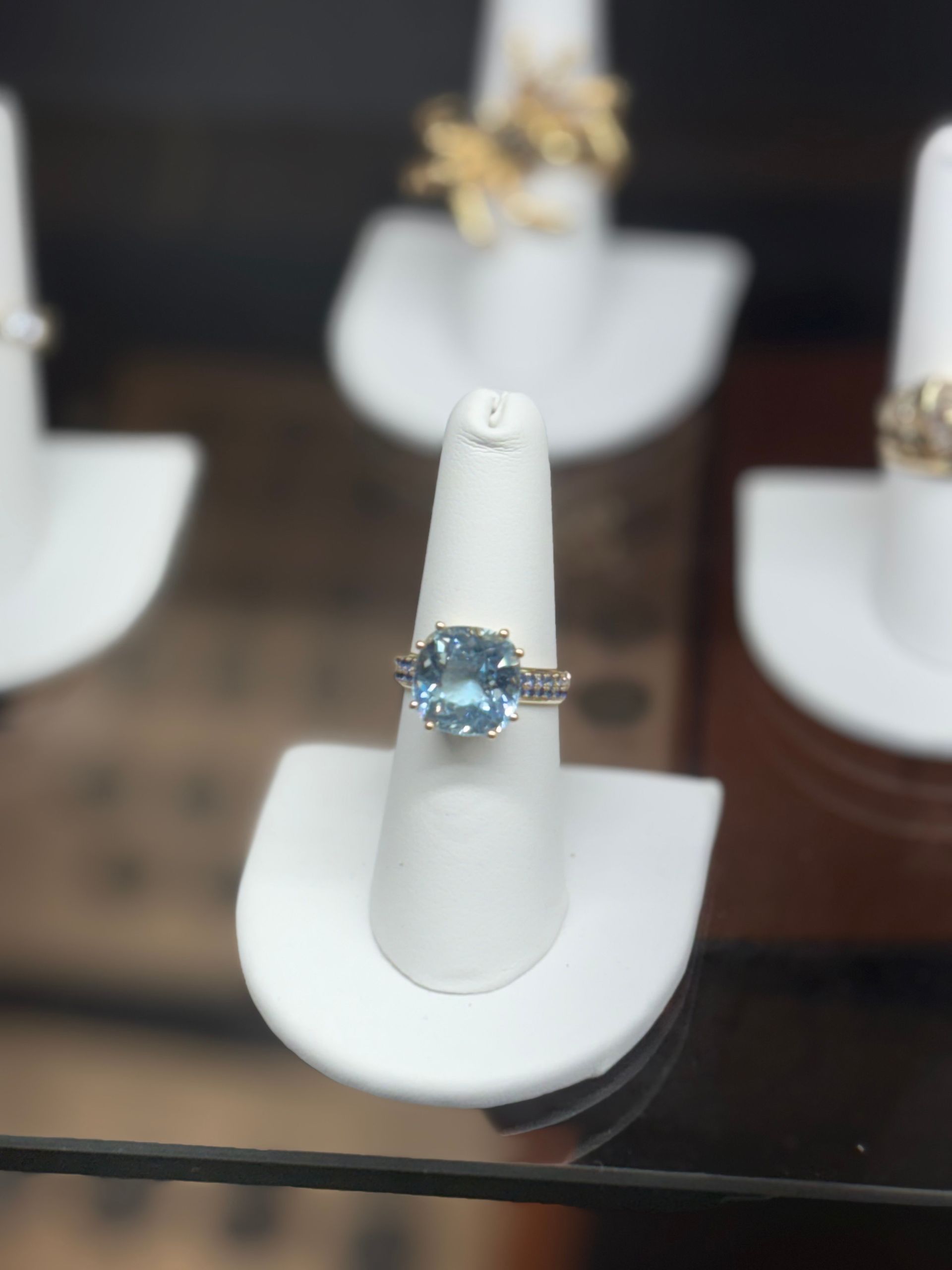 Woman's hands clasped, wearing a diamond ring. French manicure visible.