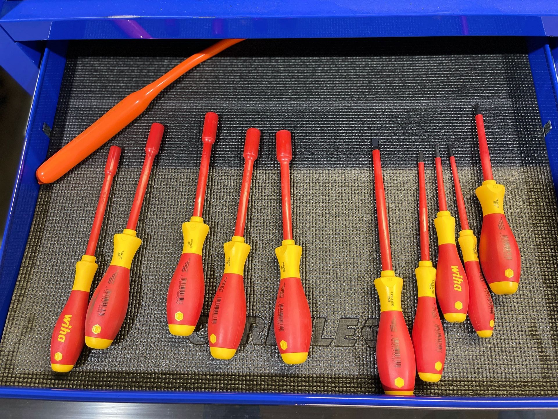 A bunch of screwdrivers are lined up in a blue drawer