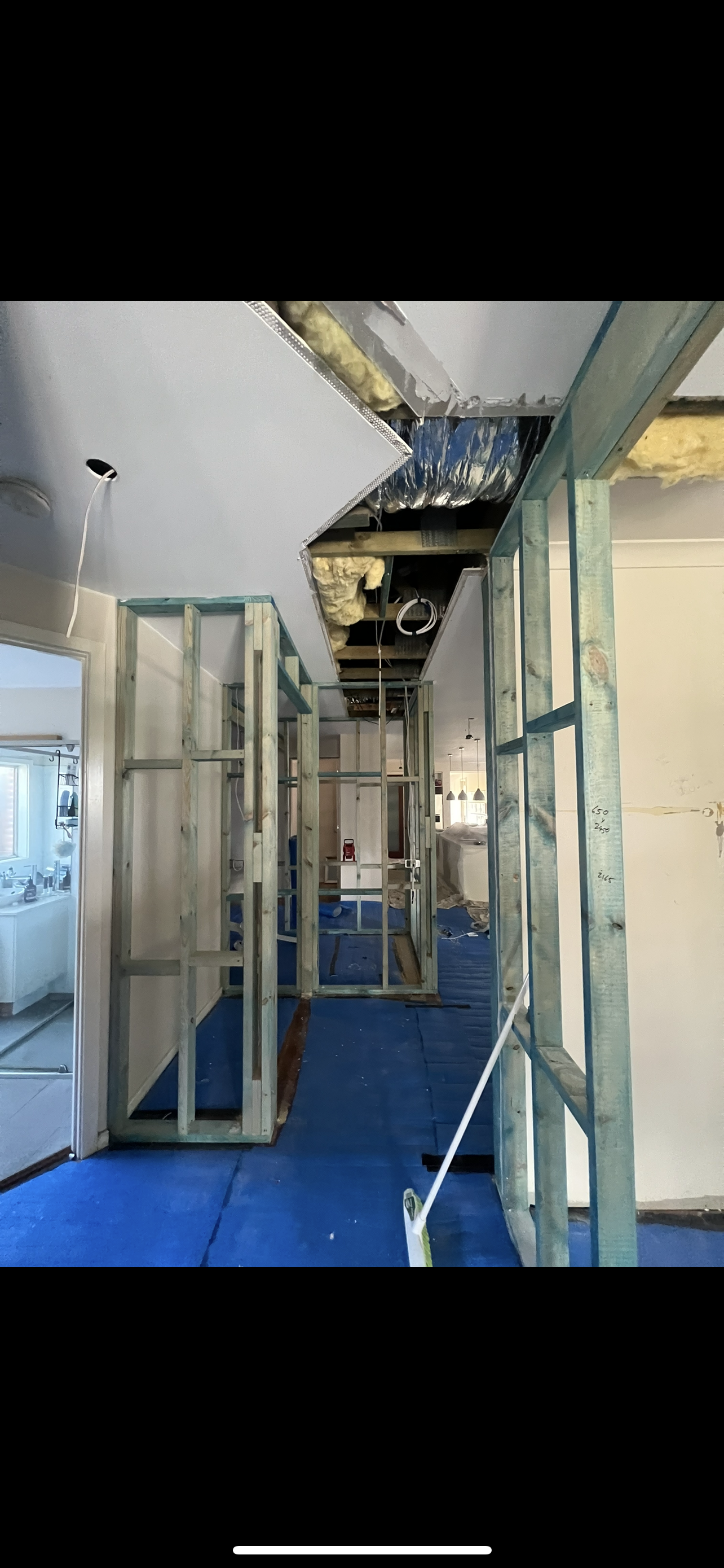 Construction site interior. Exposed metal framing and blue flooring.