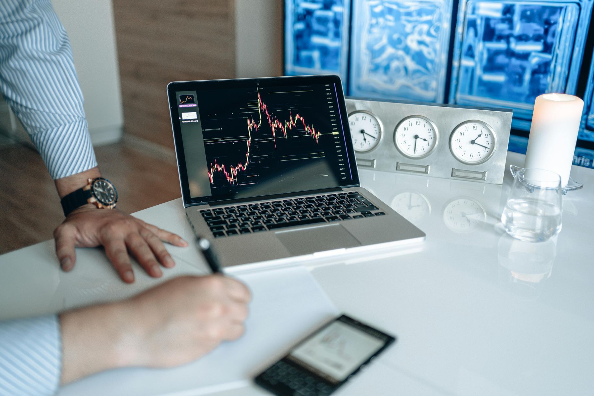A man is writing on a whiteboard with a marker.