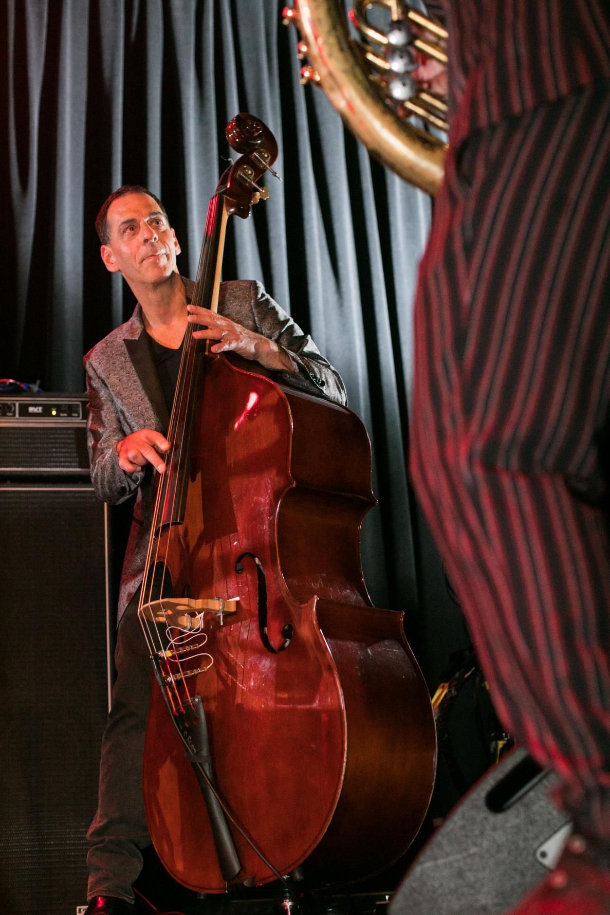 A man is playing a double bass and a man is playing a saxophone