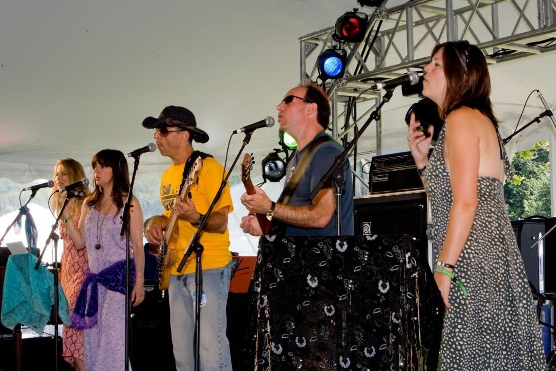 A group of people singing and playing instruments on a stage