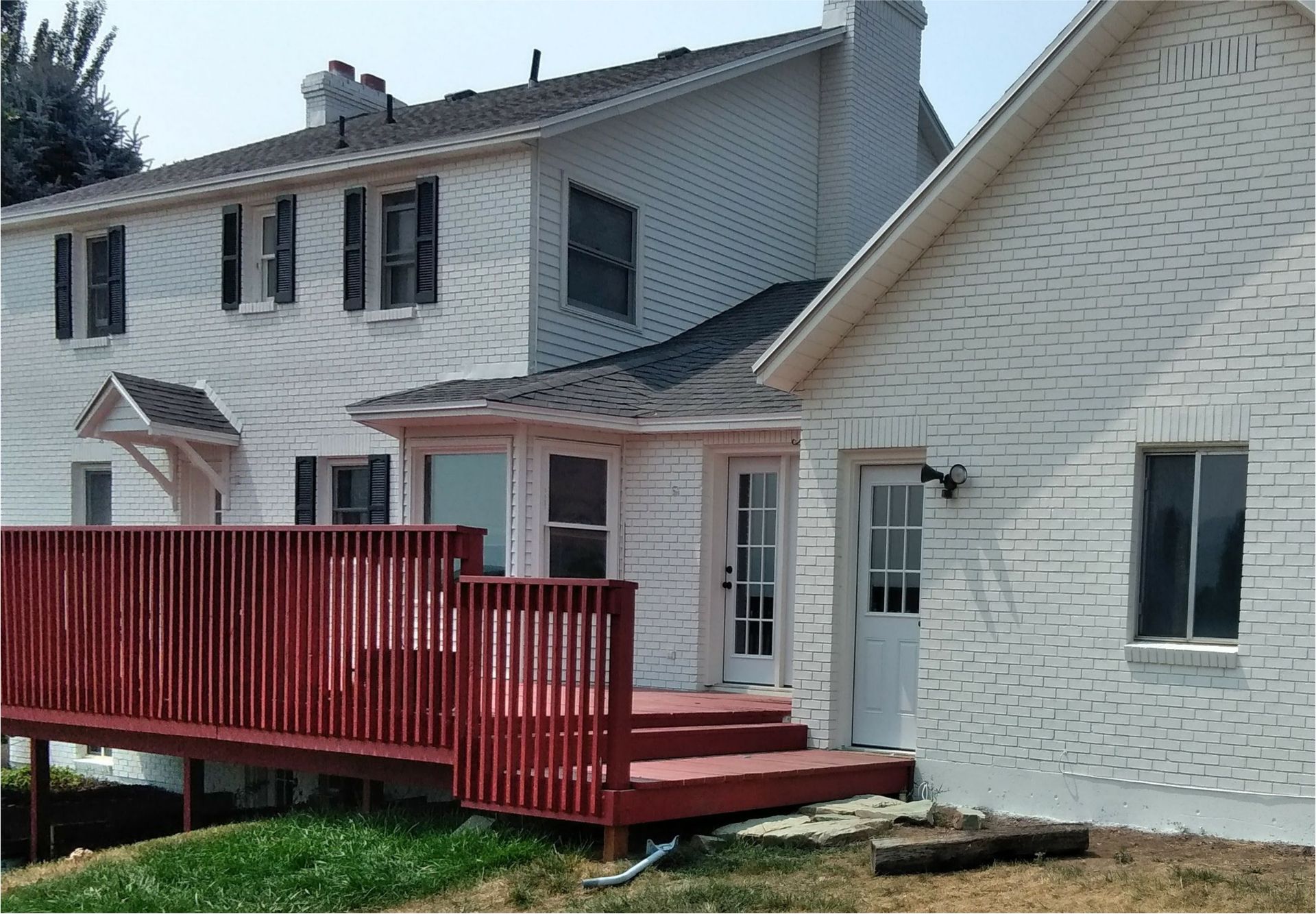 A white house with a red deck in front of it