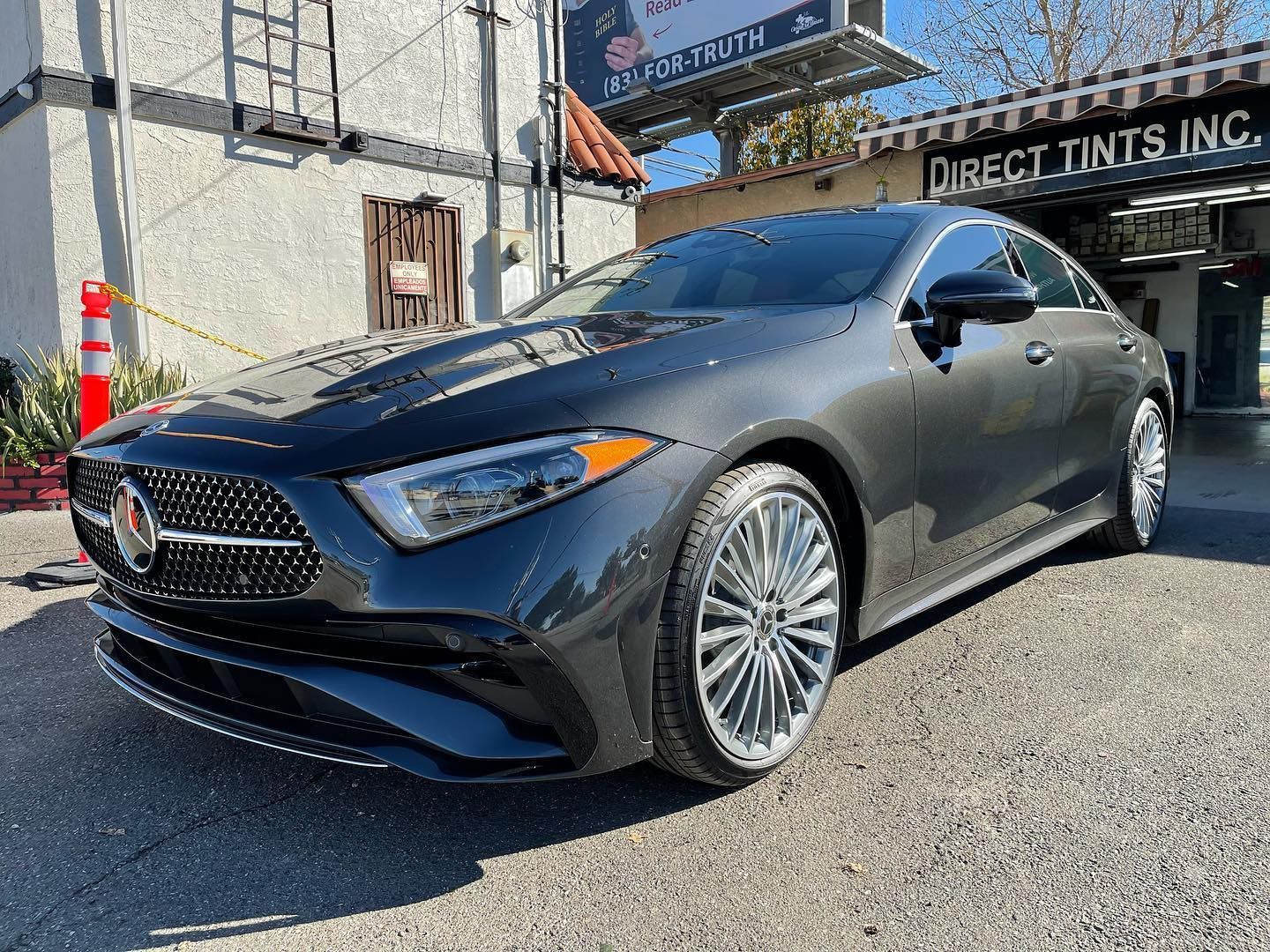 Gray Mercedes-Benz sedan parked in front of Direct Tints Inc. building.