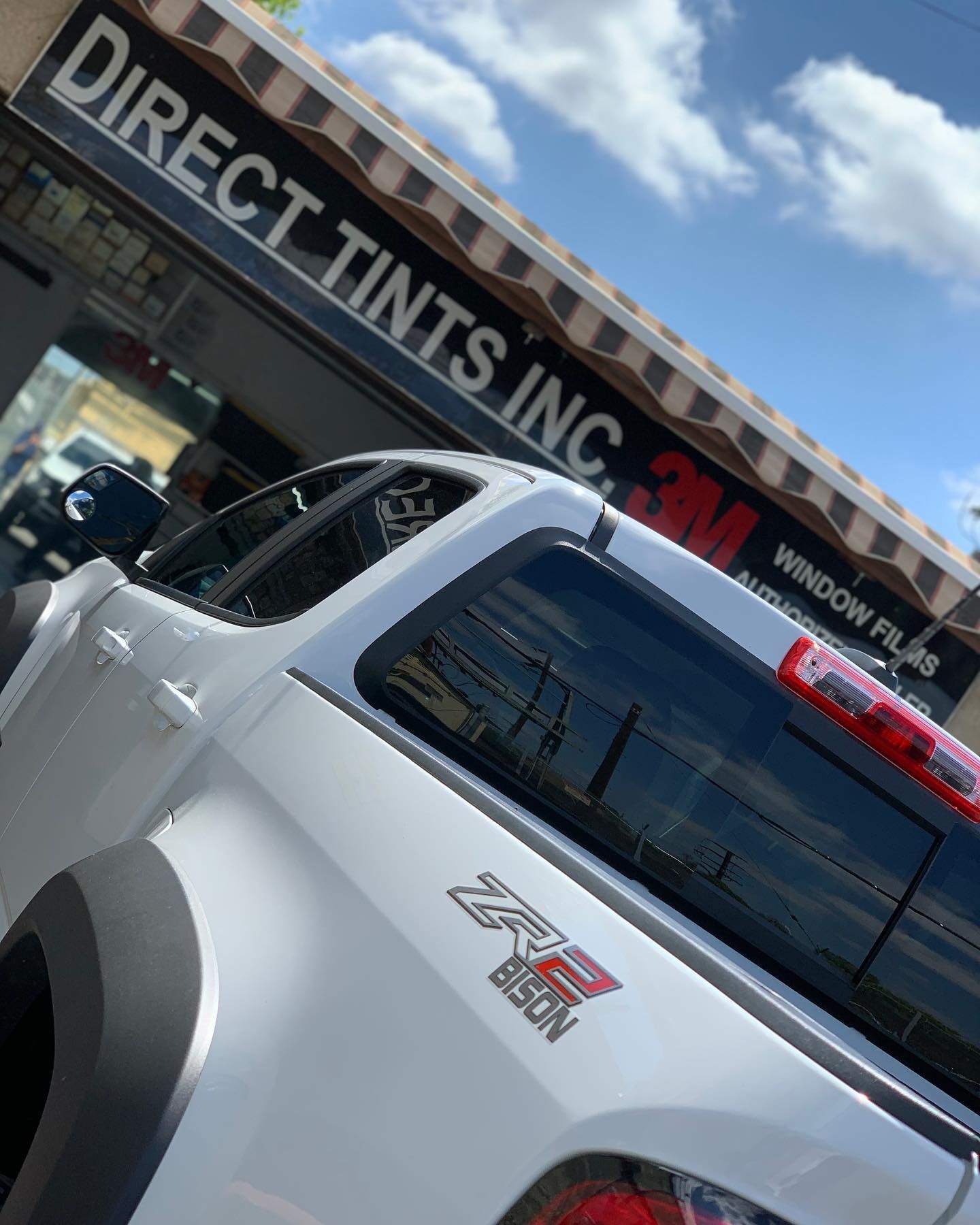 White truck with tinted windows, parked outside 
