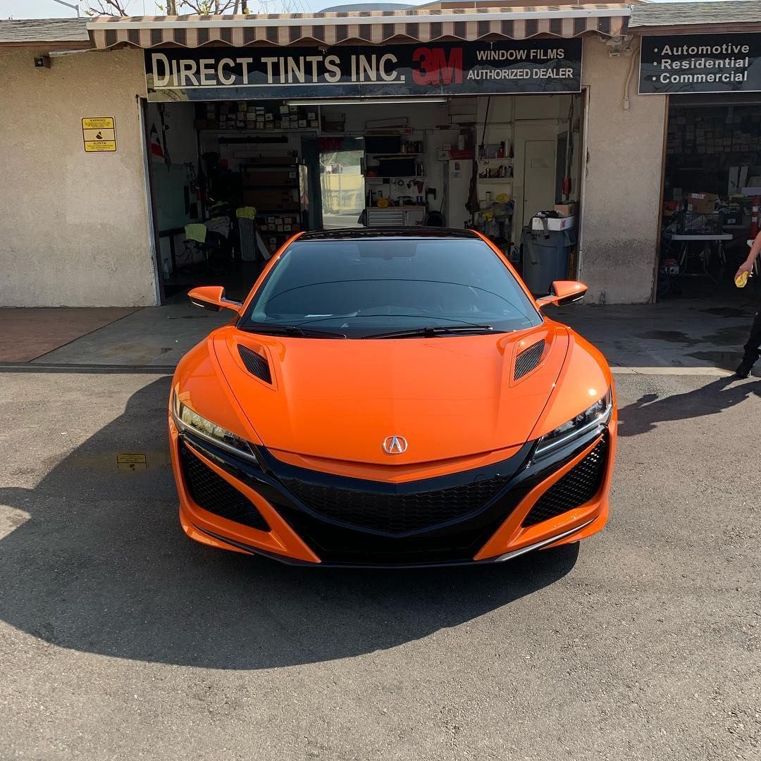 Orange Acura NSX sports car parked in front of Direct Tints Inc. building.