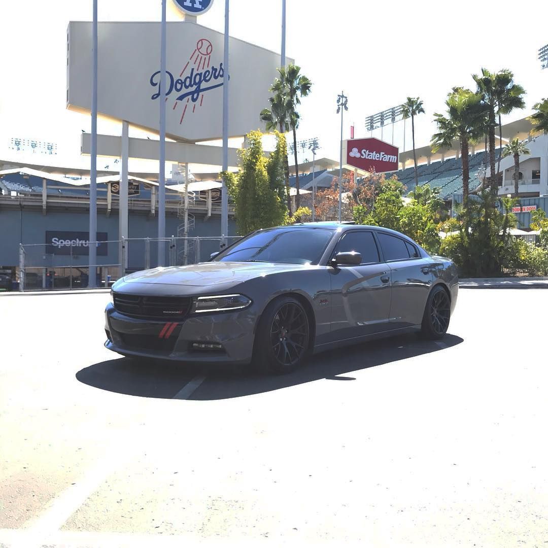 Gray Dodge Charger parked in front of Dodger Stadium sign, sunny day.