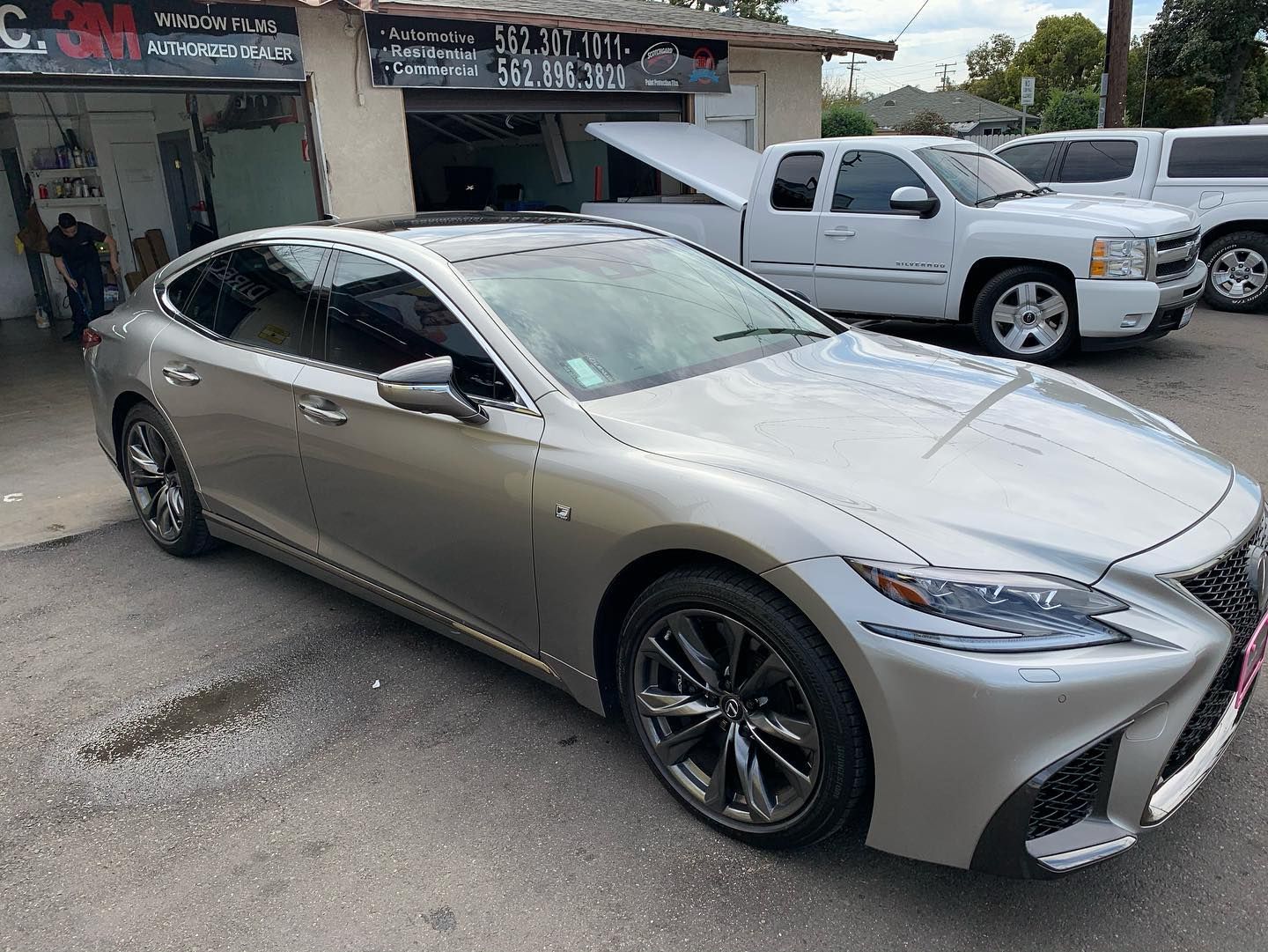 Large windows reflect a blue sky and bare trees, set in a light-colored building exterior.
