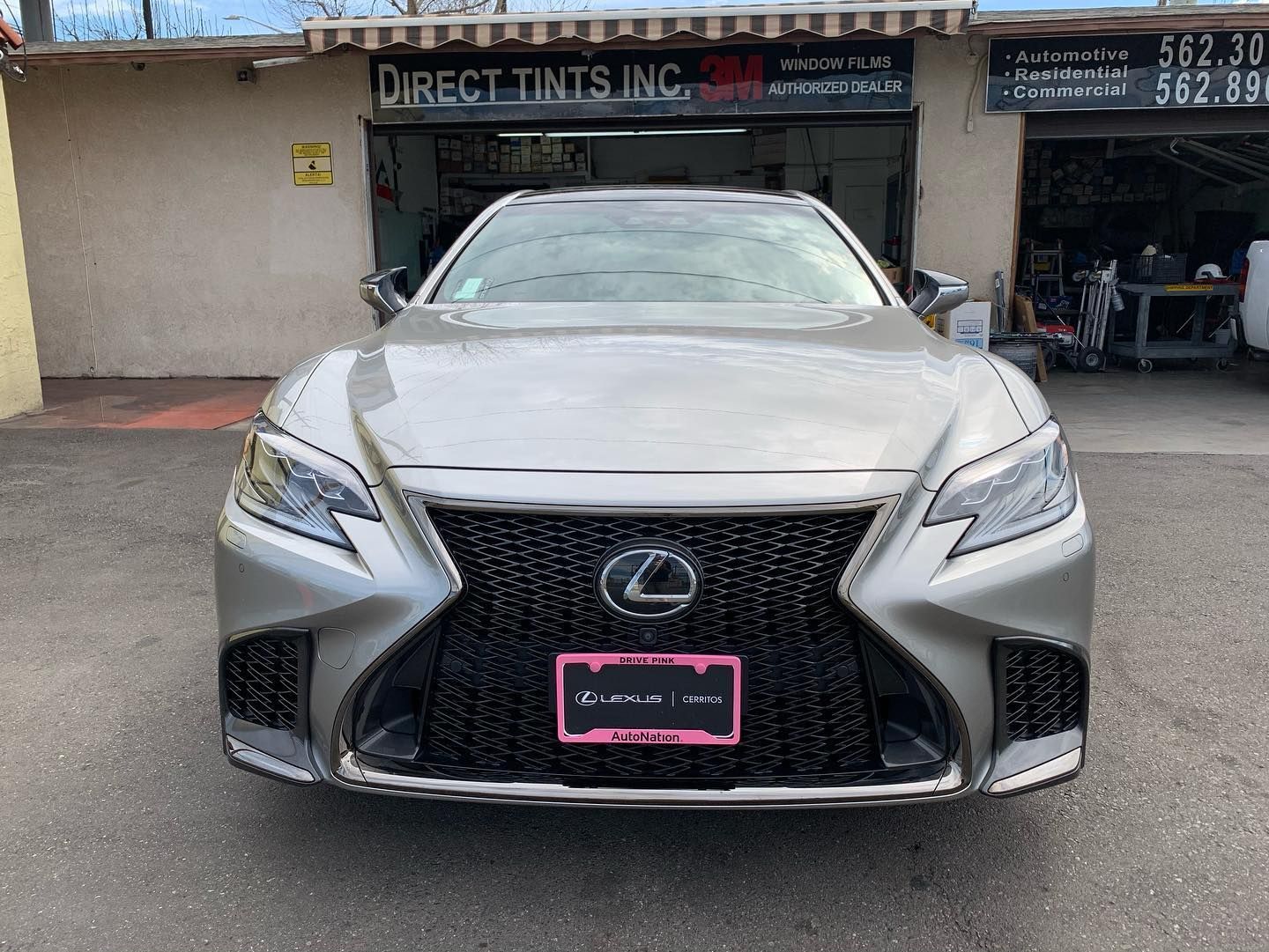 Silver Lexus sedan parked in front of a storefront with Direct Tints Inc. signage.