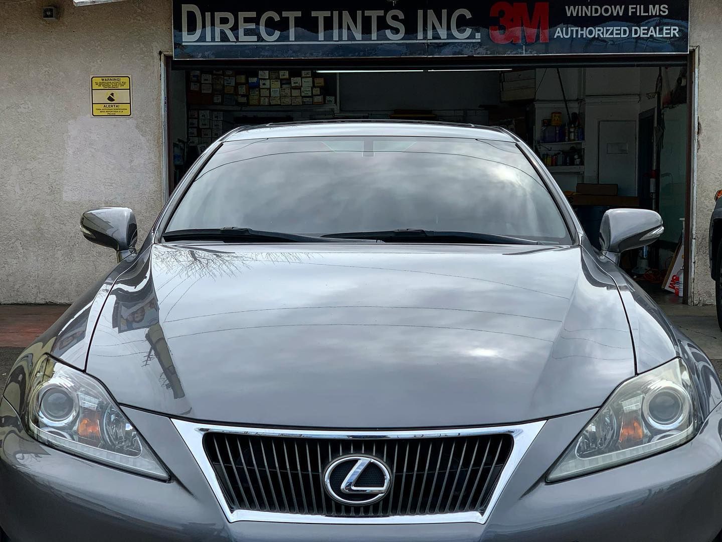 City skyline reflected in a grid of glass windows, creating a repeating view of buildings and sky.