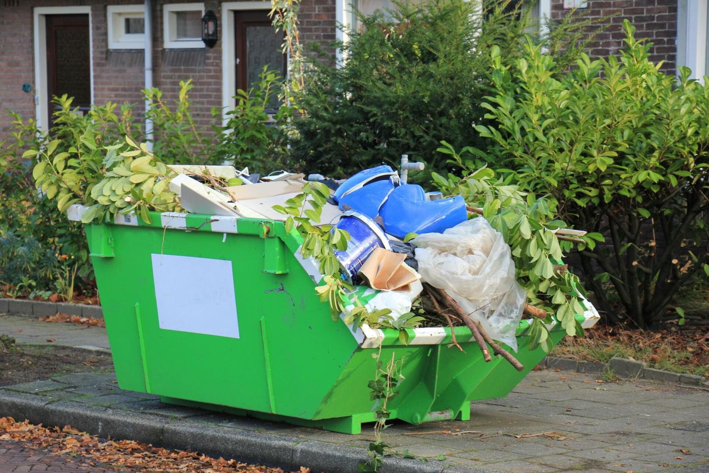 green dumpster with garbages