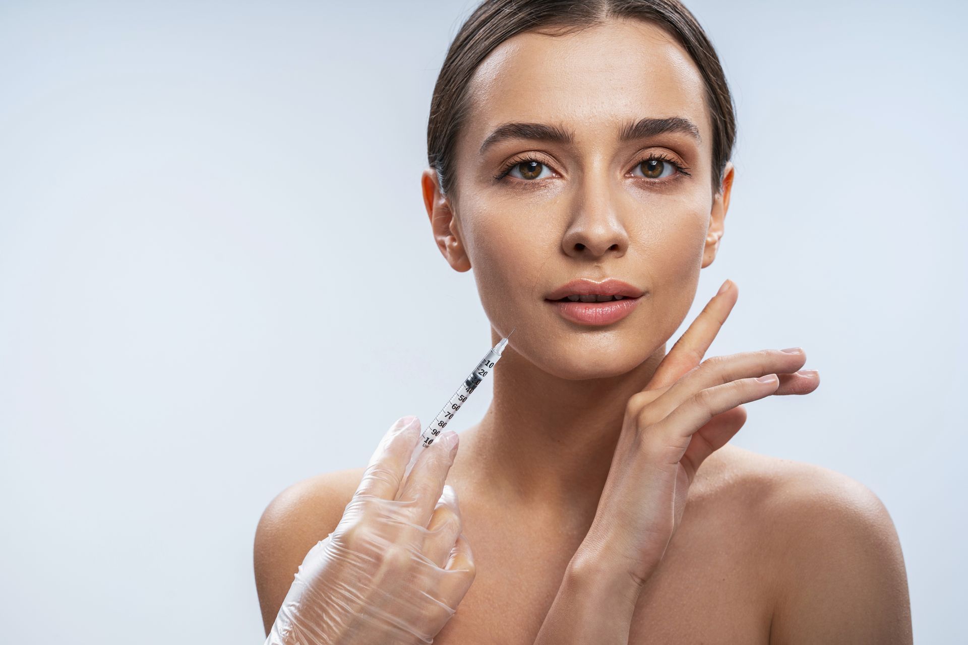 A woman is getting a botox injection in her face.