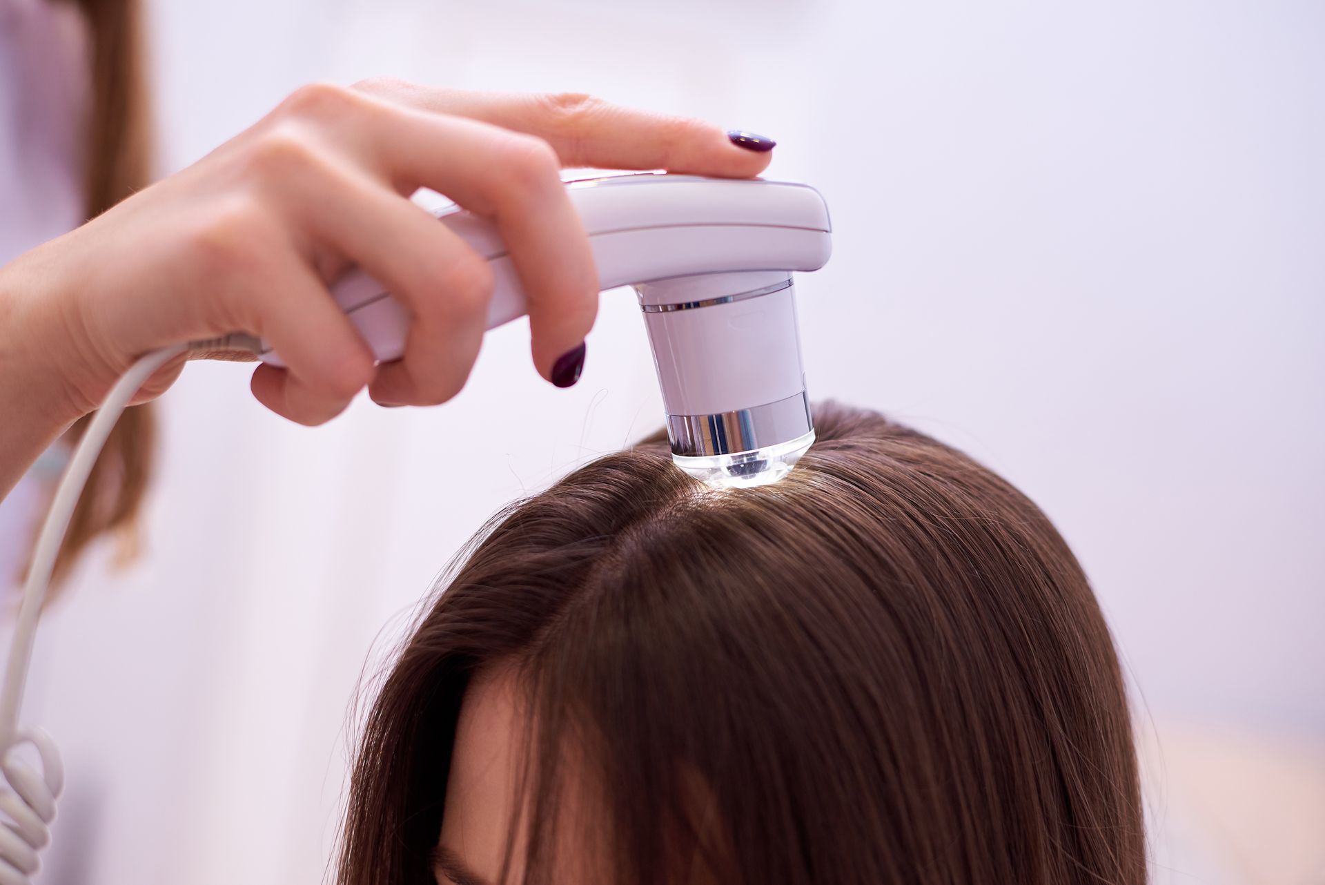 A woman is getting her hair examined by a doctor.