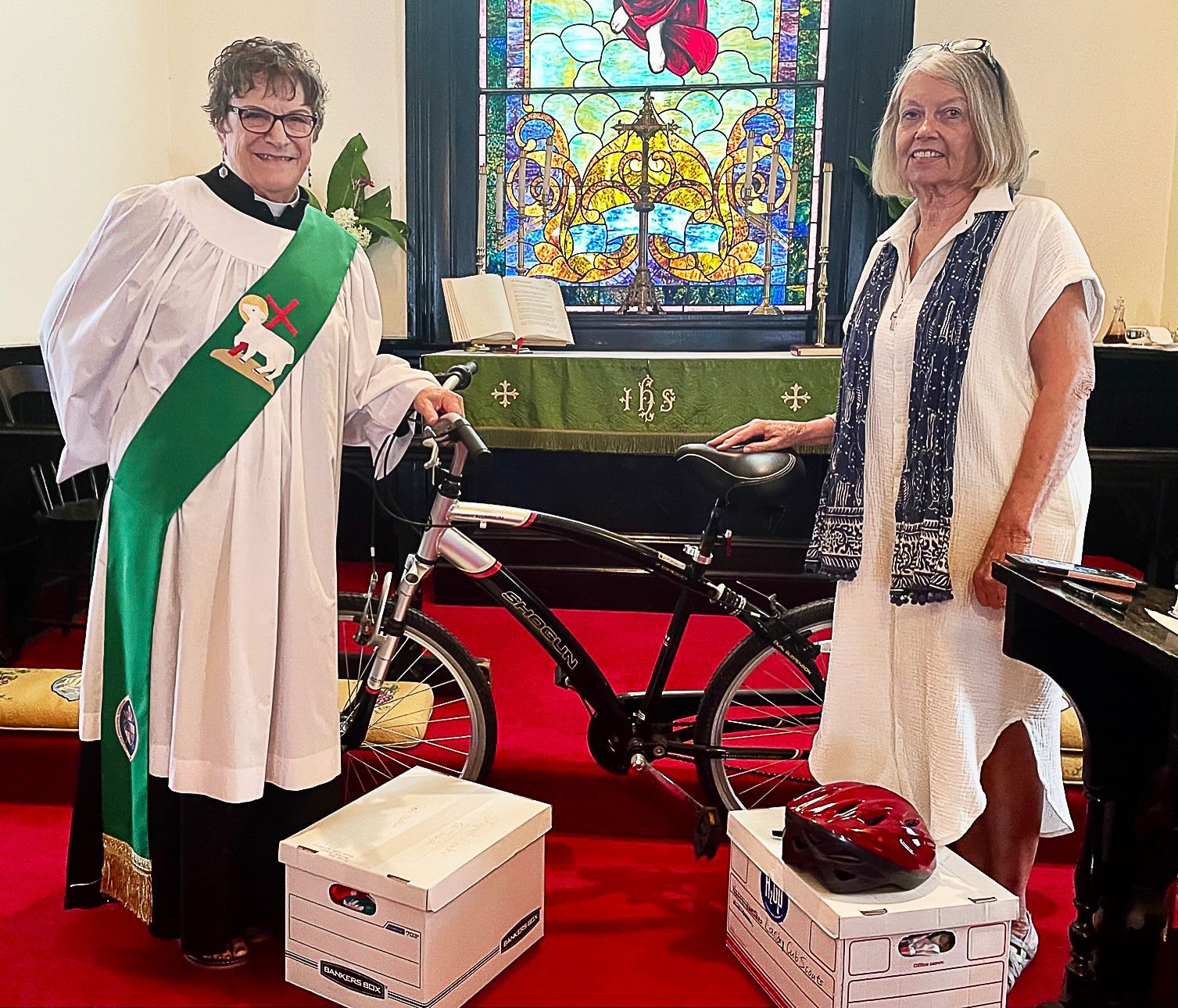 Two women standing next to a bicycle in a church