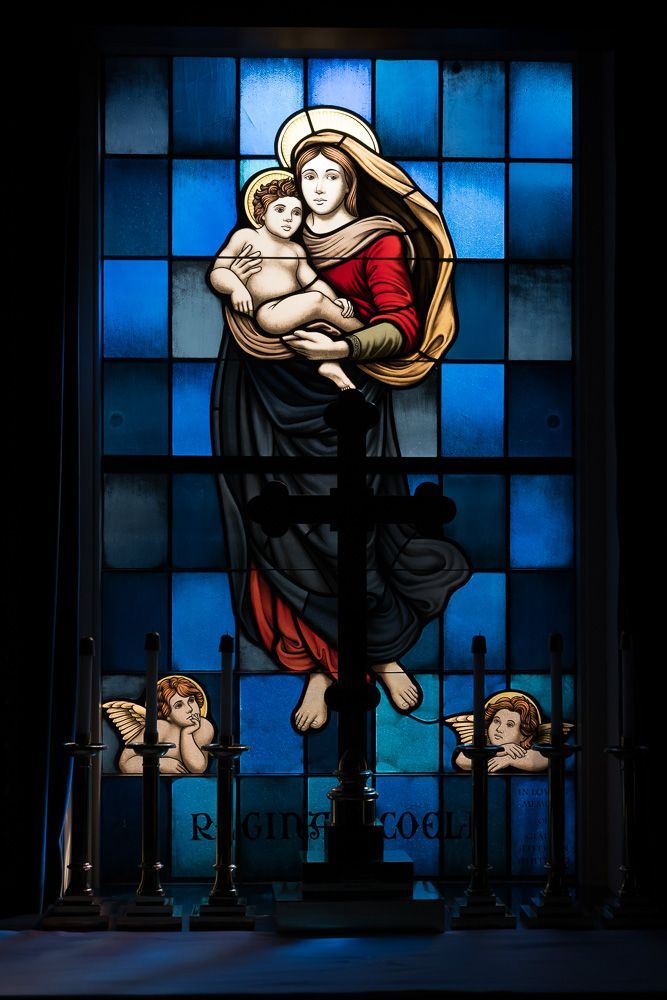 A stained glass window of a woman holding a baby