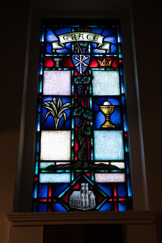 A stained glass window in a church with the word faith on it