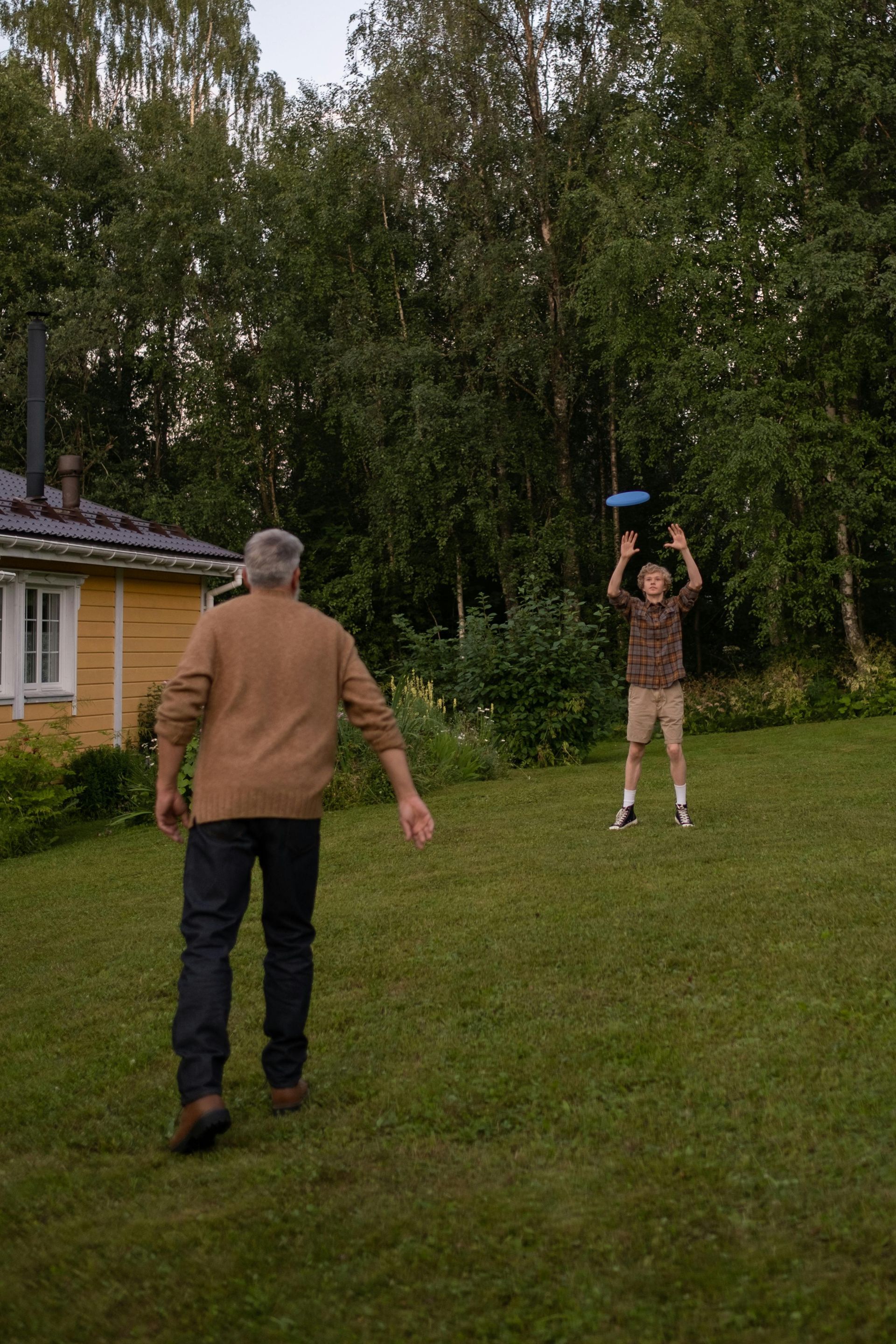 Two men are playing frisbee in a grassy field.