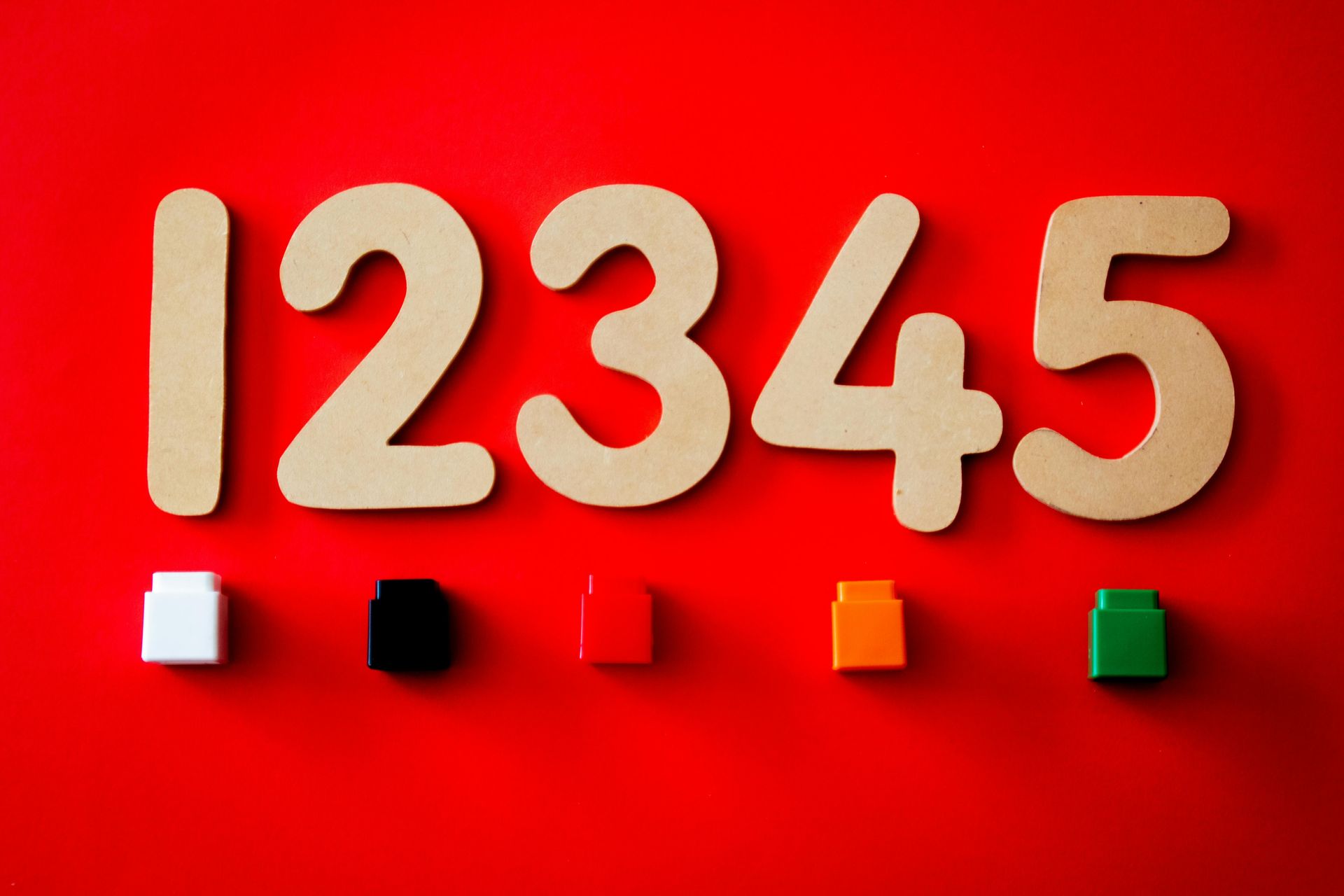 The numbers 12345 are made of wood and are on a red background