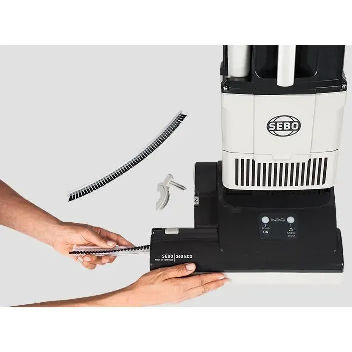 Upright vacuum cleaner, white and black, on a white background.